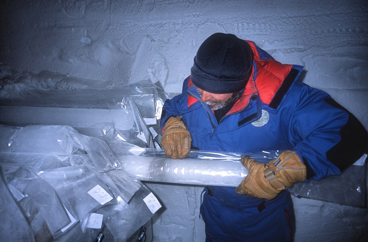A dark band of volcanic ash inside a clear cylinder of drilled ice