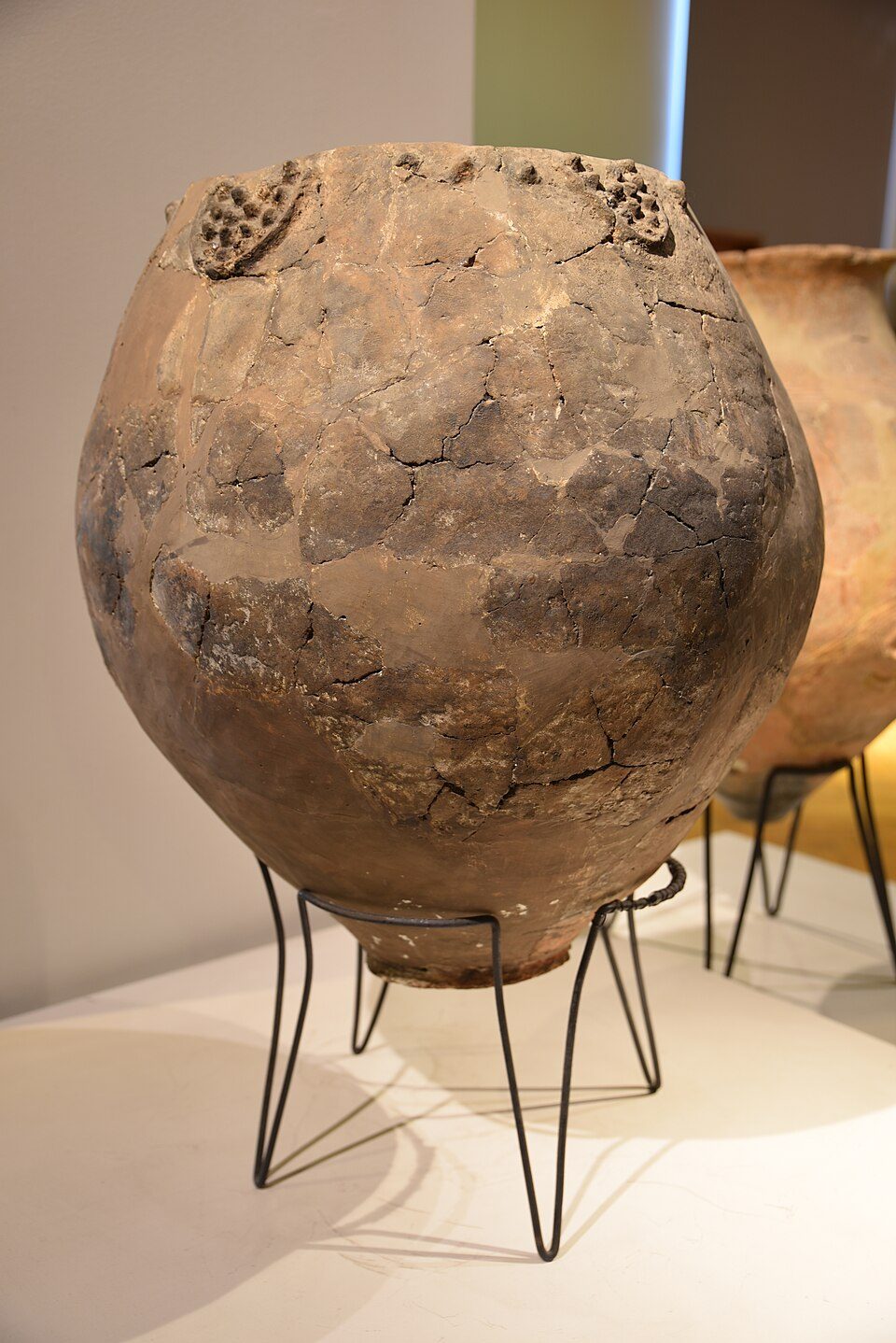 A large earthenware jar decorated with carved bunches of grapes