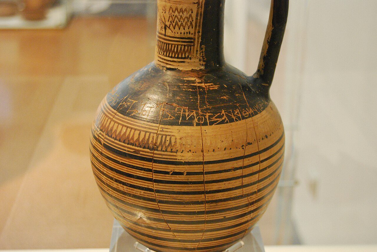 A line of early Greek alphabetic letters scratched into a clay jug.