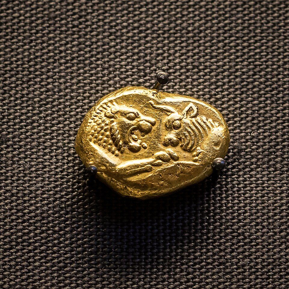 A gold coin stamped with the foreparts of a lion and a bull.