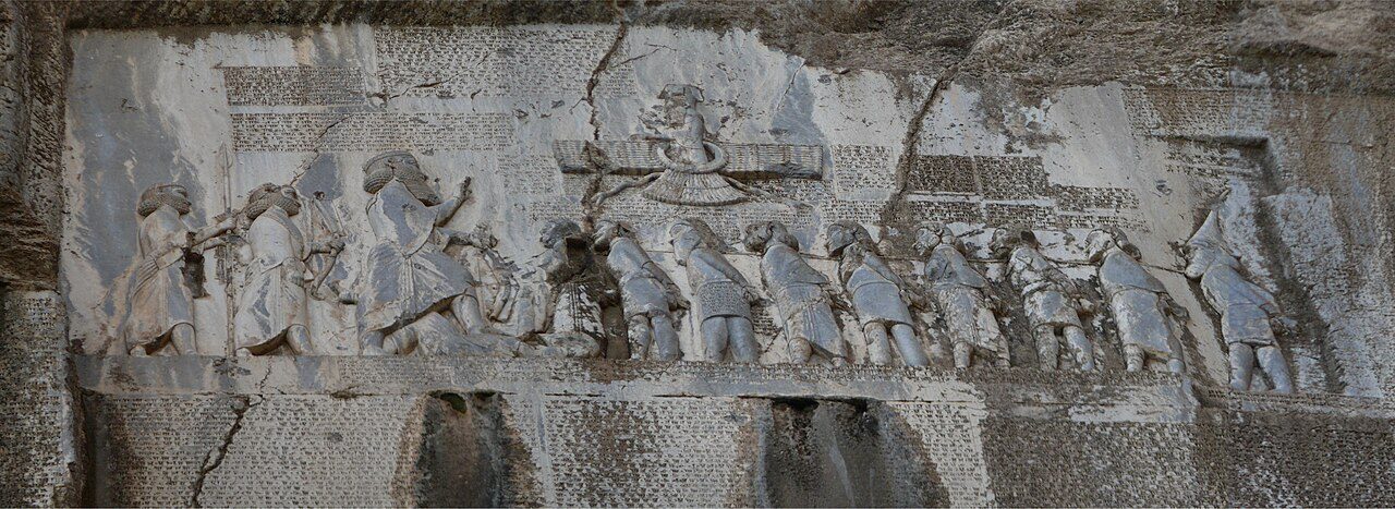 A cliff relief and cuneiform inscription showing Darius over defeated rivals.