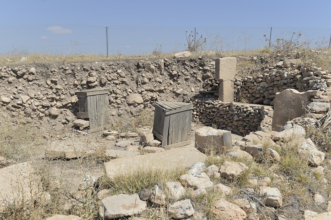 Massive carved T-shaped stone pillars standing in an excavated circle